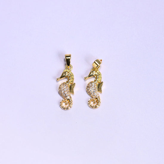 Gold colourway of the sea horse zirconia pendant, two 18K gold plated charms side by side, one square to camera and one angled to show the snap bail.