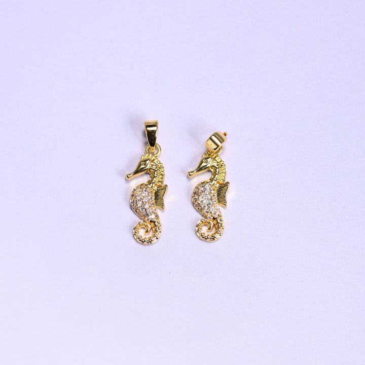 Gold colourway of the sea horse zirconia pendant, two 18K gold plated charms side by side, one square to camera and one angled to show the snap bail.