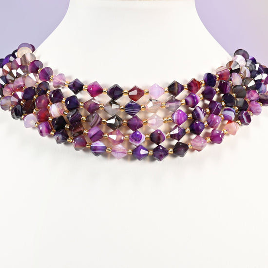 Strand of 8mm Dyed Purple Strip Agate faceted bicone beads worn on a jewelry display bust, showing the necklace-length drape.