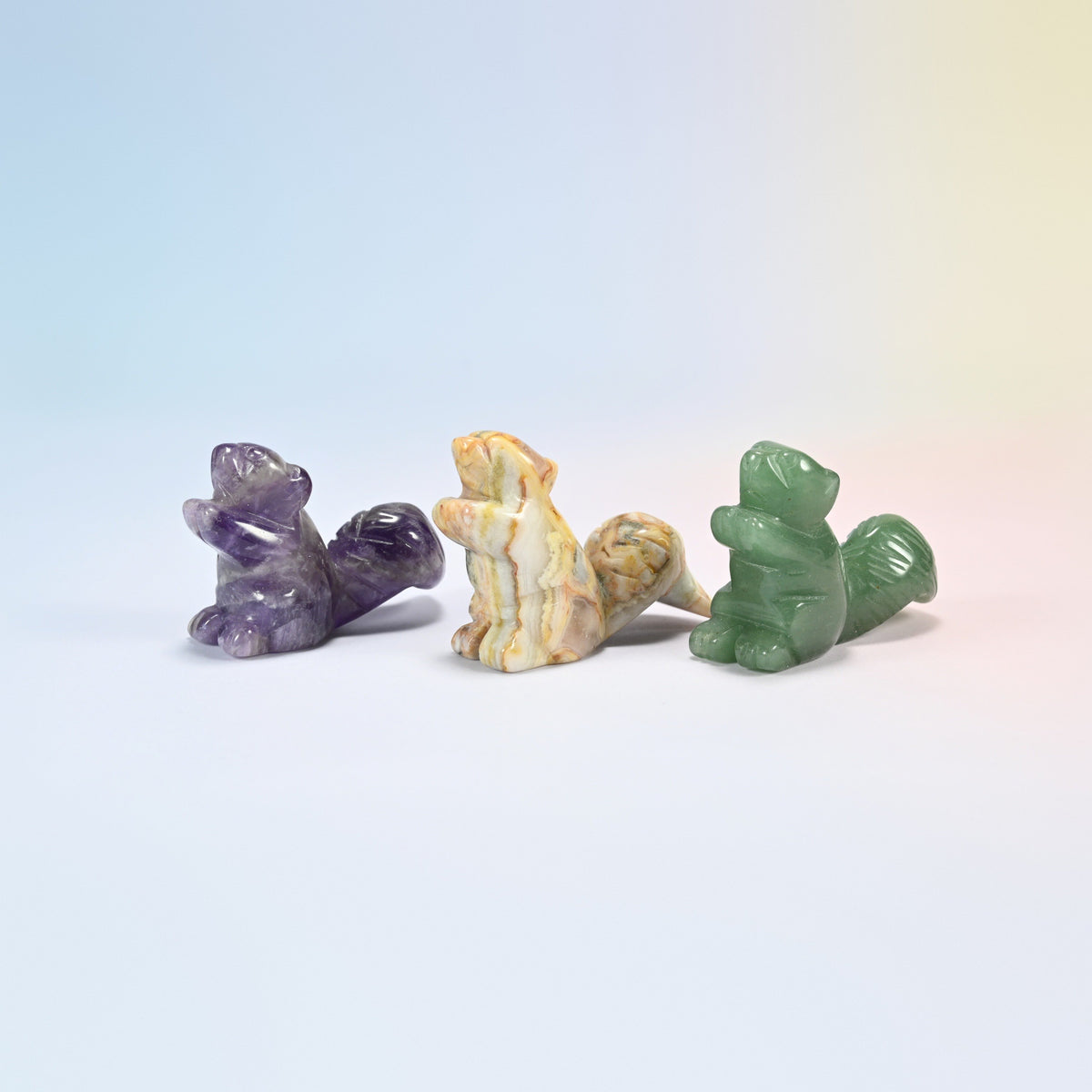 Three 2 inch long tail squirrel carvings in natural amethyst, natural crazy agate and natural green aventurine