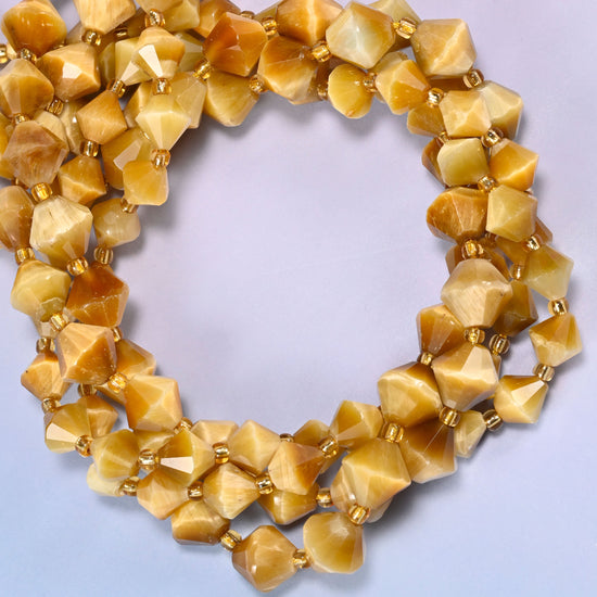 Gold tiger eye bicone beads coiled into a round ring of several strands, a soft golden shimmer traveling around the coil.