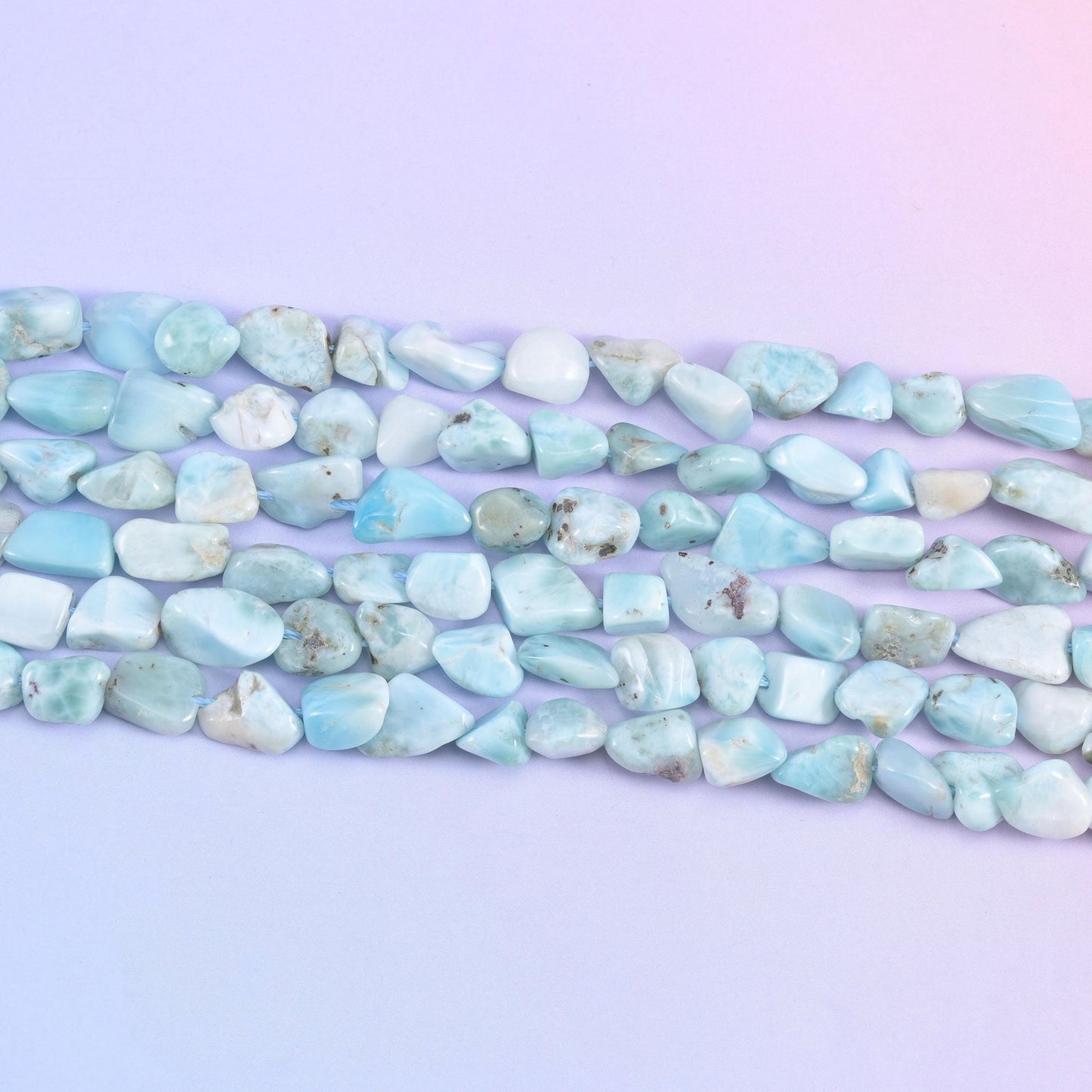 Strands stretched flat, the small tumbled nuggets showing how their sizes and shapes differ