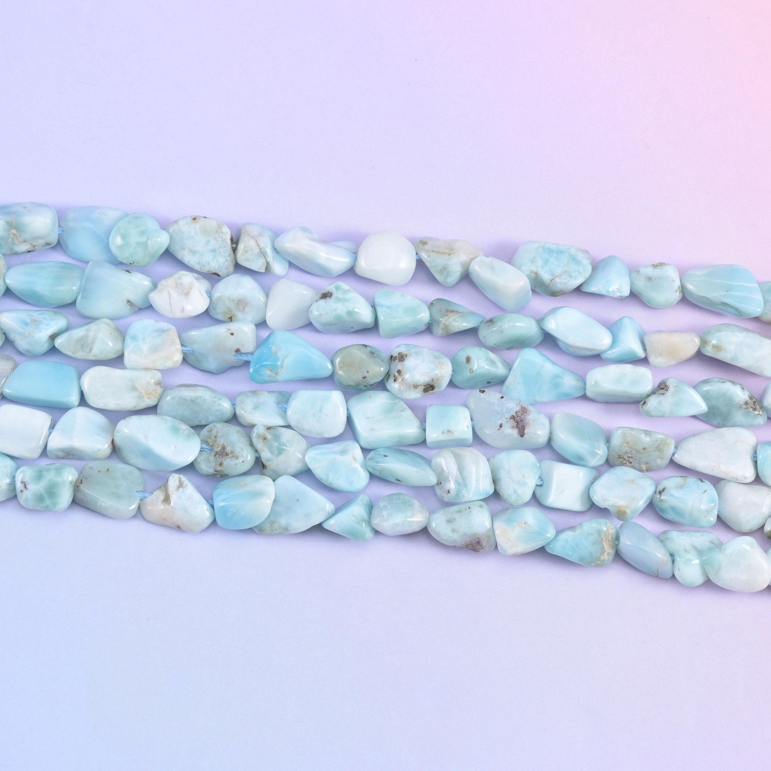 Strands stretched flat, the small tumbled nuggets showing how their sizes and shapes differ