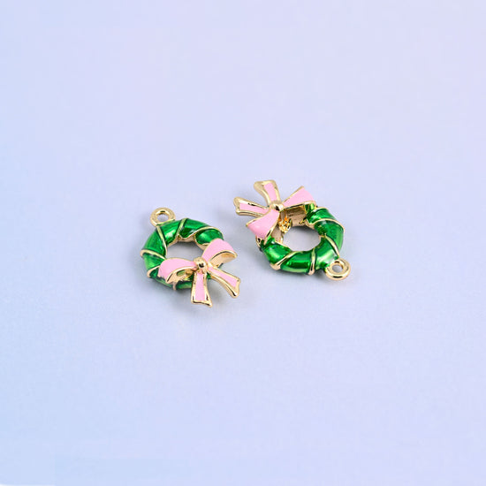 Two wreath charms, one face on and one turned to show the light pink bow from the side.