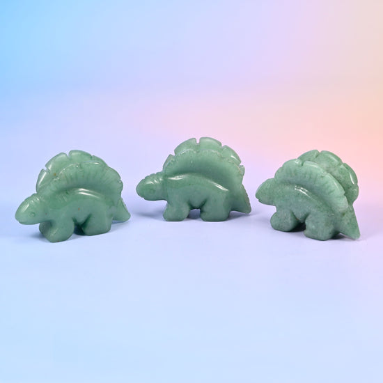 Stegosaurus dinosaur crystal carving, about 2 inches, with a ridged row of plates along its back