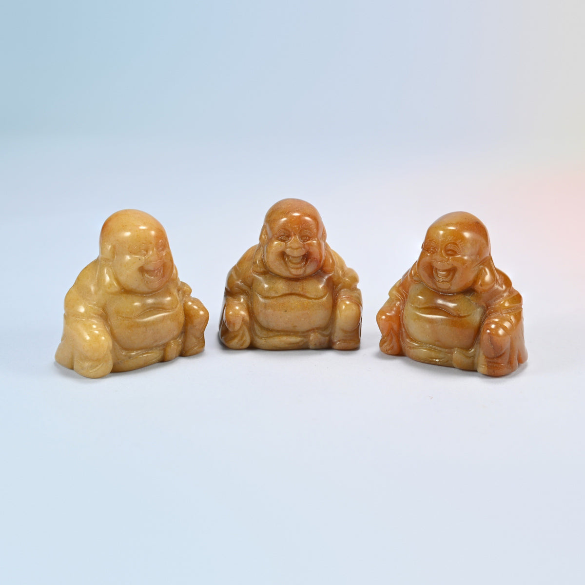 Three yellow jade laughing Buddha crystal carvings, honey yellow and caramel natural stone