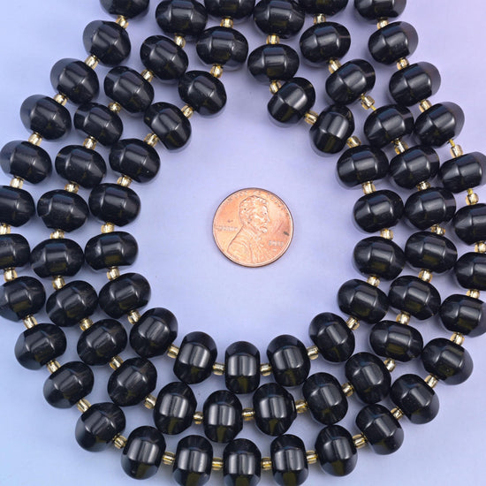 Pumpkin rondelles coiled around a penny, bead width clear against the flat coin