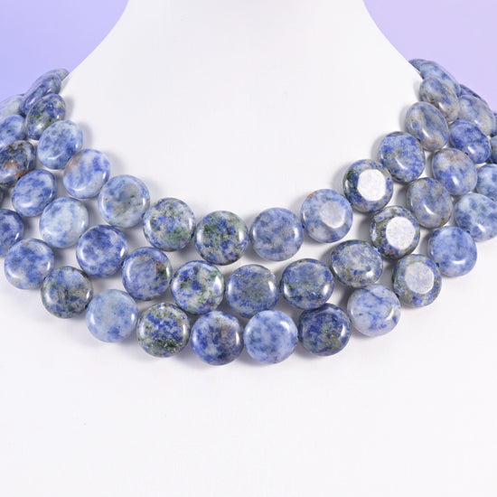 Three rows of 15mm blue spot jasper coins on a white neck form, forming a soft mottled collar