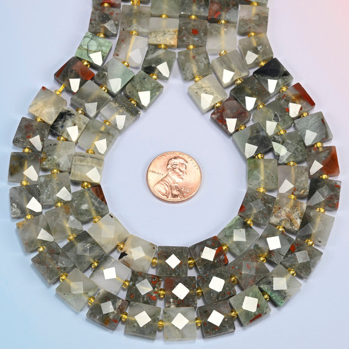 Natural African bloodstone faceted flat square strands formed into a teardrop loop around a US penny for scale