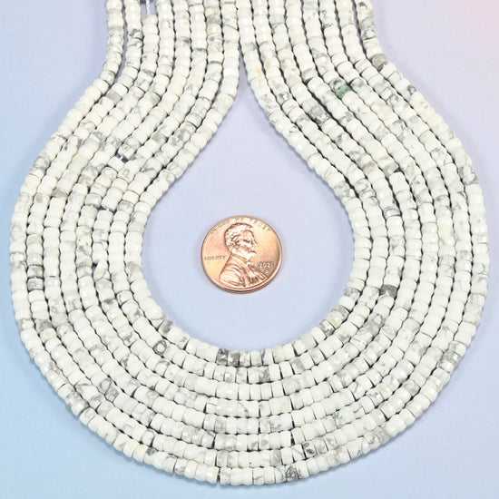 White howlite faceted heishi disc strands formed into a teardrop loop around a US penny for scale