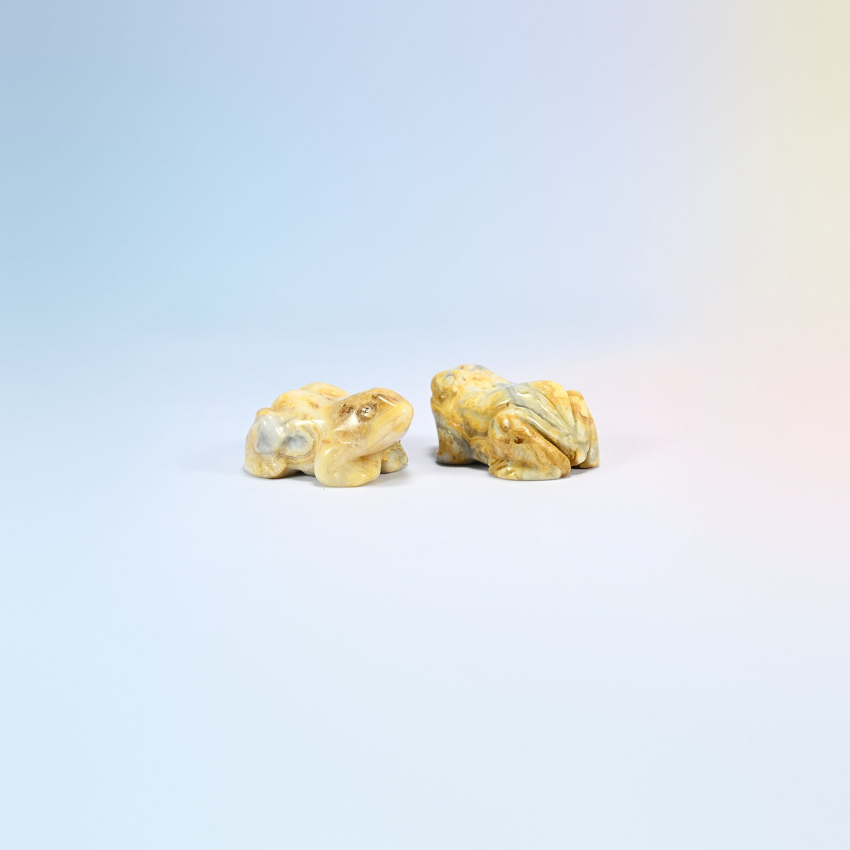 Two natural crazy agate frog carvings, yellow and gray swirled agate