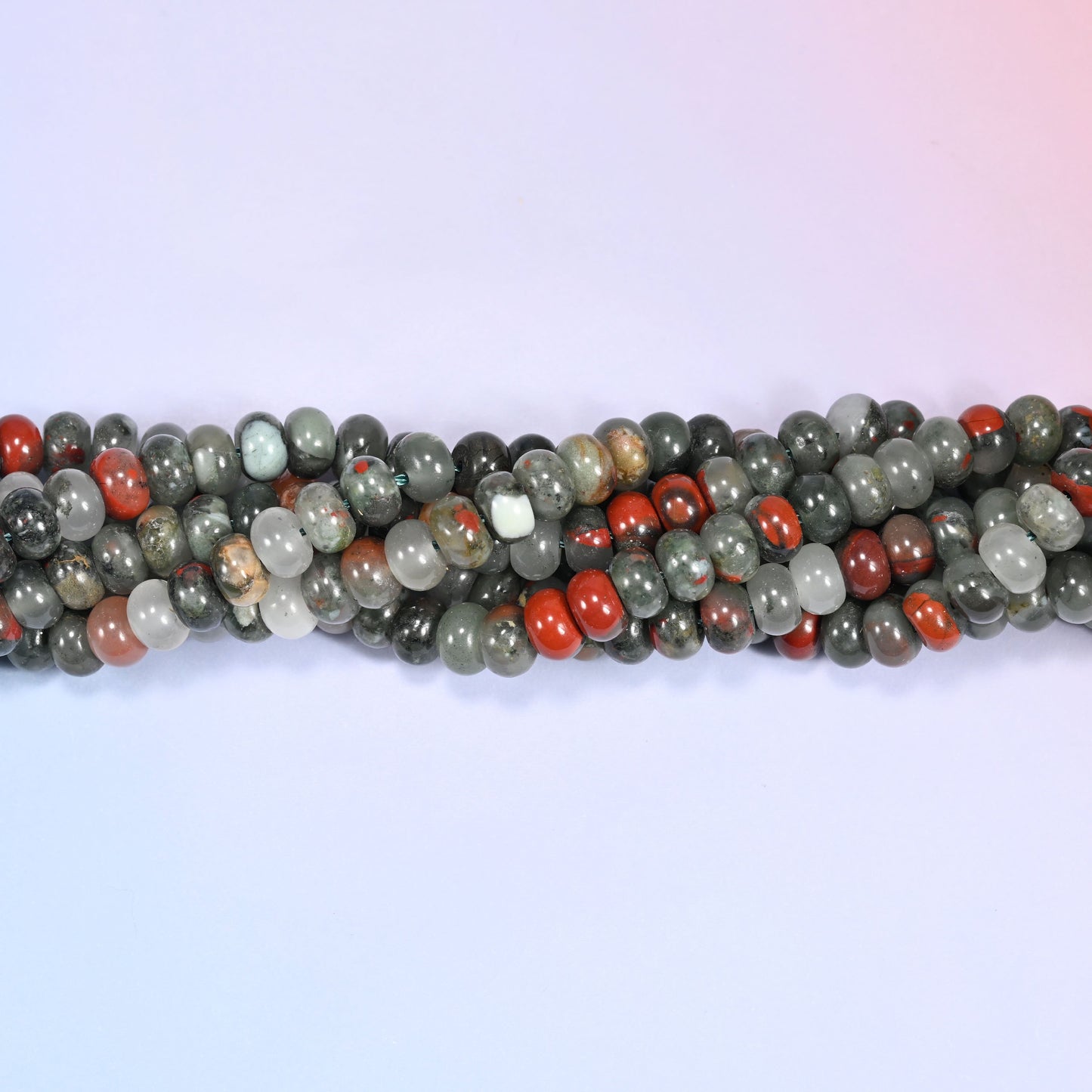 Close-up of coiled African Bloodstone beads showing the natural texture and red jasper spotting.