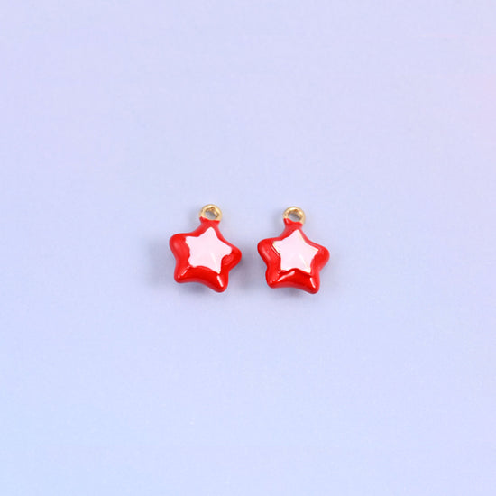 Red star charms with a light pink inset star, glossy enamel over 18K gold plated brass, 14 x 11mm.