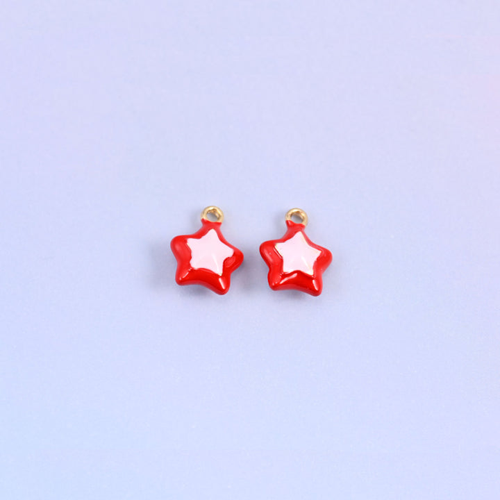 Red star charms with a light pink inset star, glossy enamel over 18K gold plated brass, 14 x 11mm.