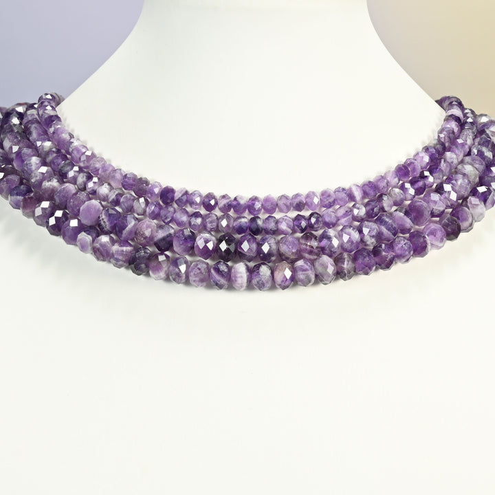 Chevron amethyst beads shown on a white neck display, the faceted rondelle strands sitting close to the neckline