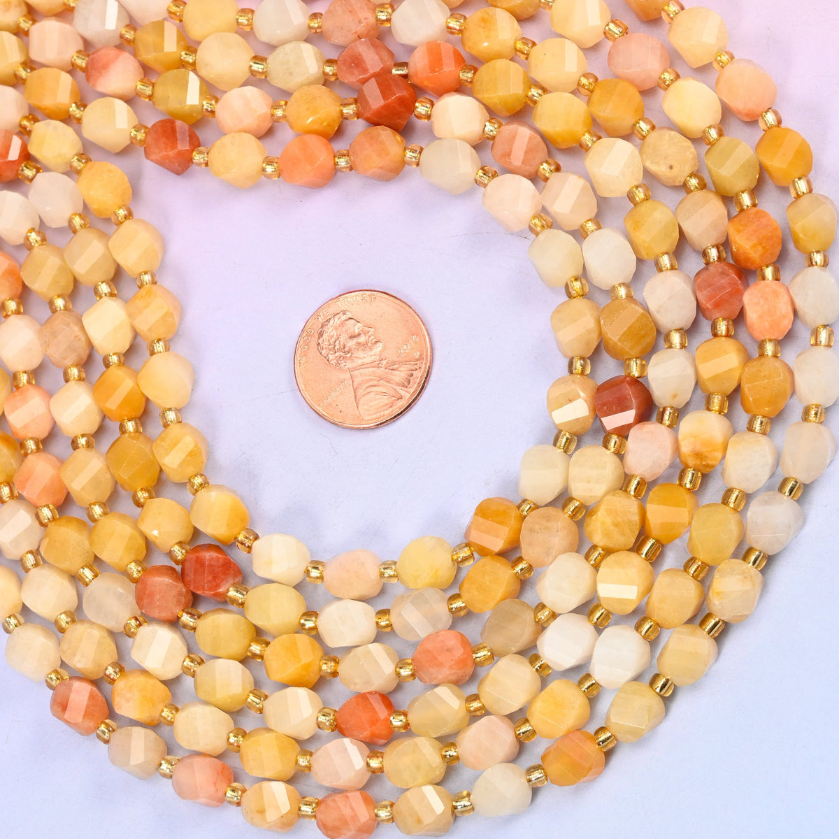 Gold silk jade yellow jade beads running from near-cream through honey yellow to deeper peach on one strand