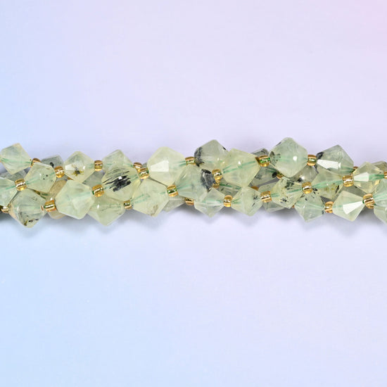 Macro close-up of Green Prehnite faceted bicone beads on a strand, showing the faceted cut and natural stone inclusions in detail.