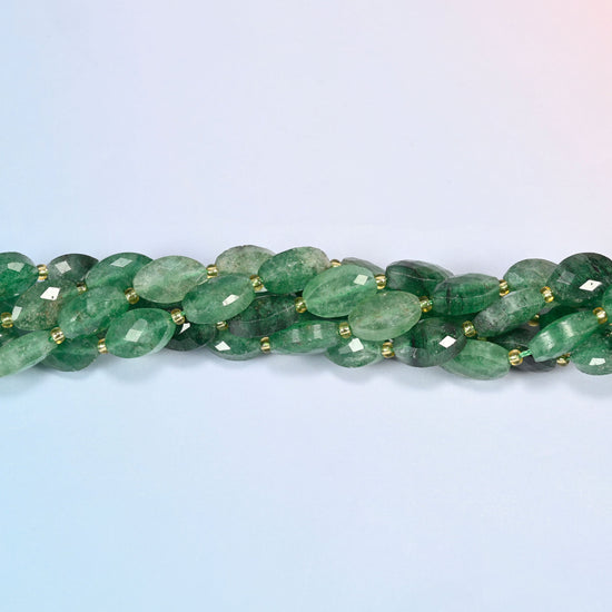Strands of green strawberry quartz faceted flat oval beads twisted together in a horizontal row
