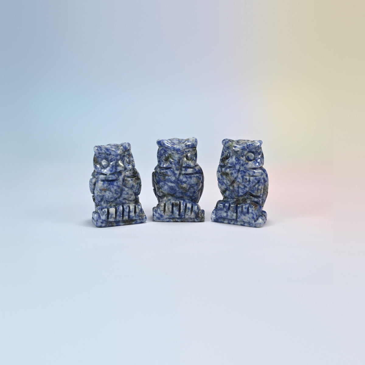 Owl crystal carving in blue spot jasper, white natural stone with blue spots