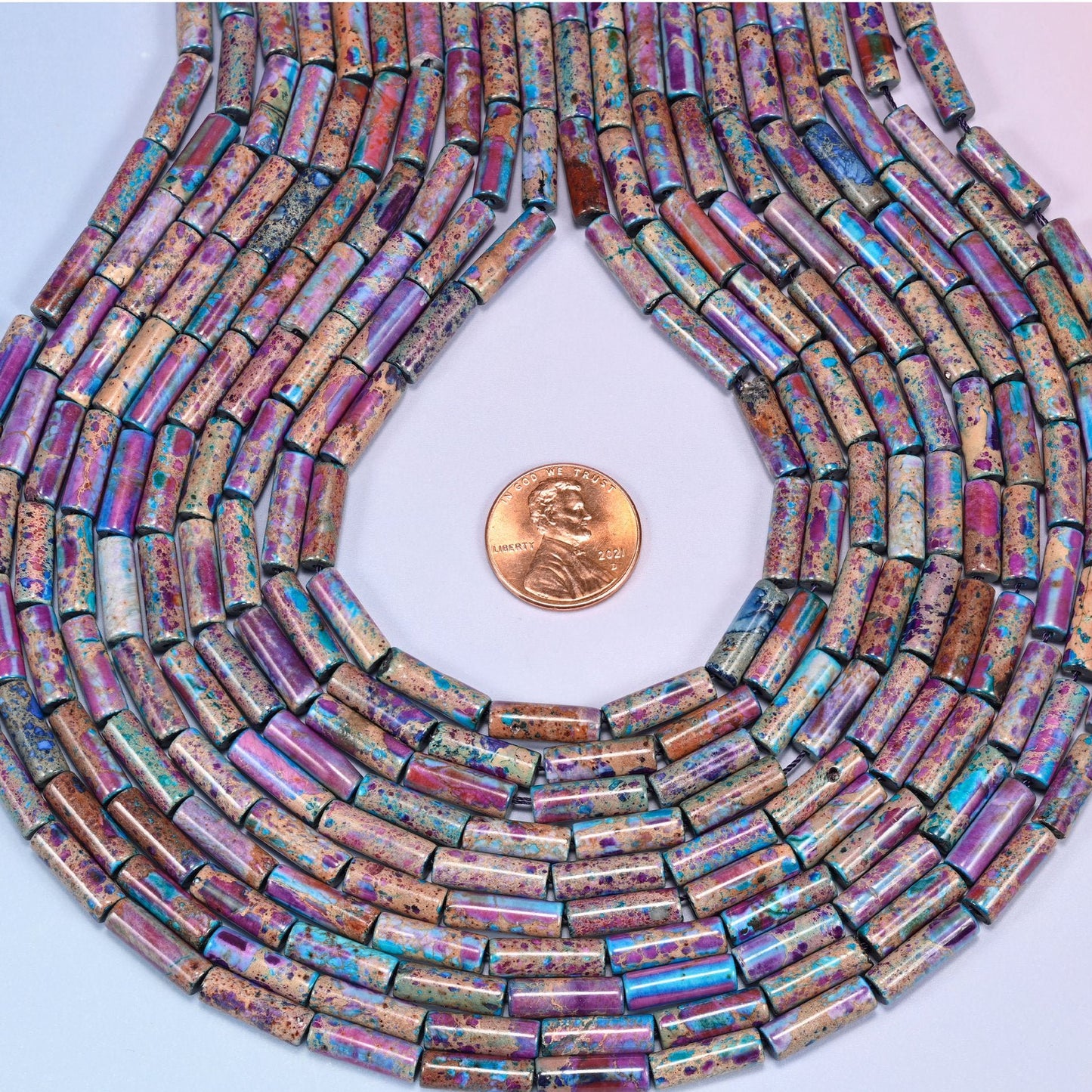Multicolor Sea Sediment Jasper tube beads featuring purple, magenta, turquoise and deep blue over a tan mineral-veined base.