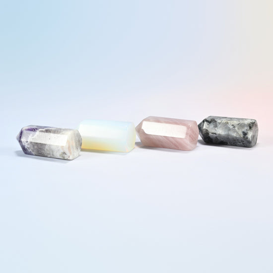 Four 1.4 inch hexagon crystal points laid in a row, amethyst, opalite, rose quartz and black labradorite