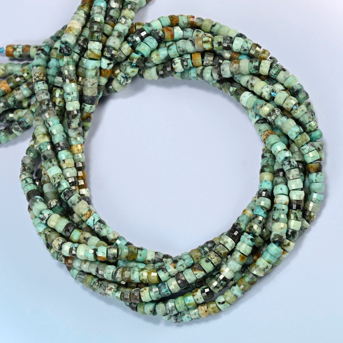 African howlite faceted heishi disc beads coiled into overlapping loops, whole strands of green stone with dark veining
