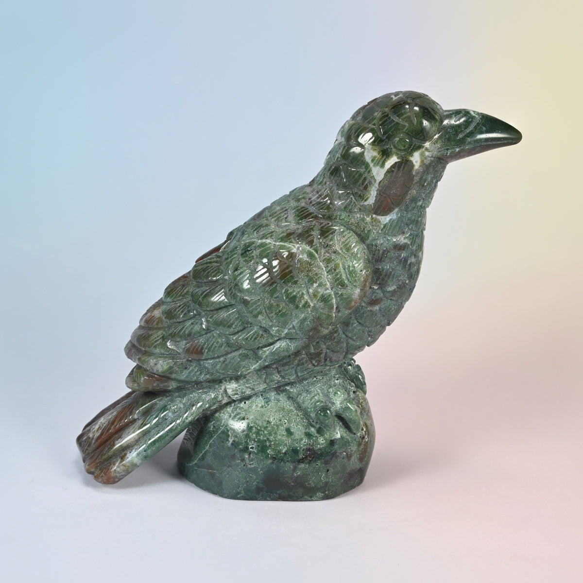 5 inch natural Indian agate crow carving on a rock base, side view facing right, green with red patches