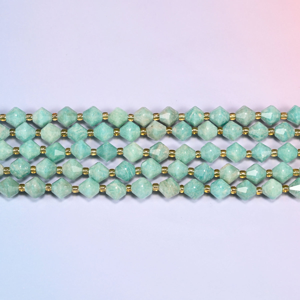 Green Amazonite faceted bicone beads 8mm with gold-tone spacers, strand laid straight in a wide view showing the beaded texture