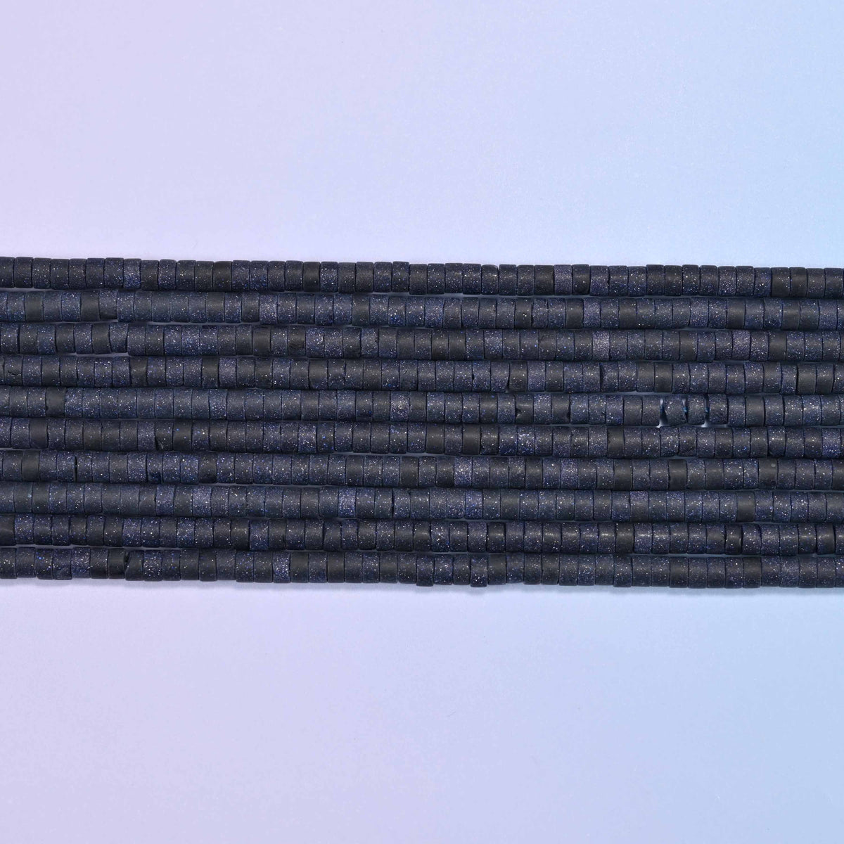 Blue sandstone beads in deep blue with shimmering copper flecks
