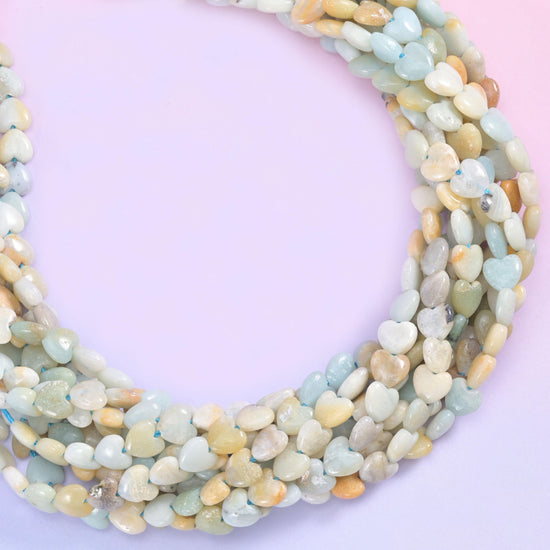 Pale seafoam green, cream, chalky white and sandy mustard tones mixed along the same strand, small puffed hearts