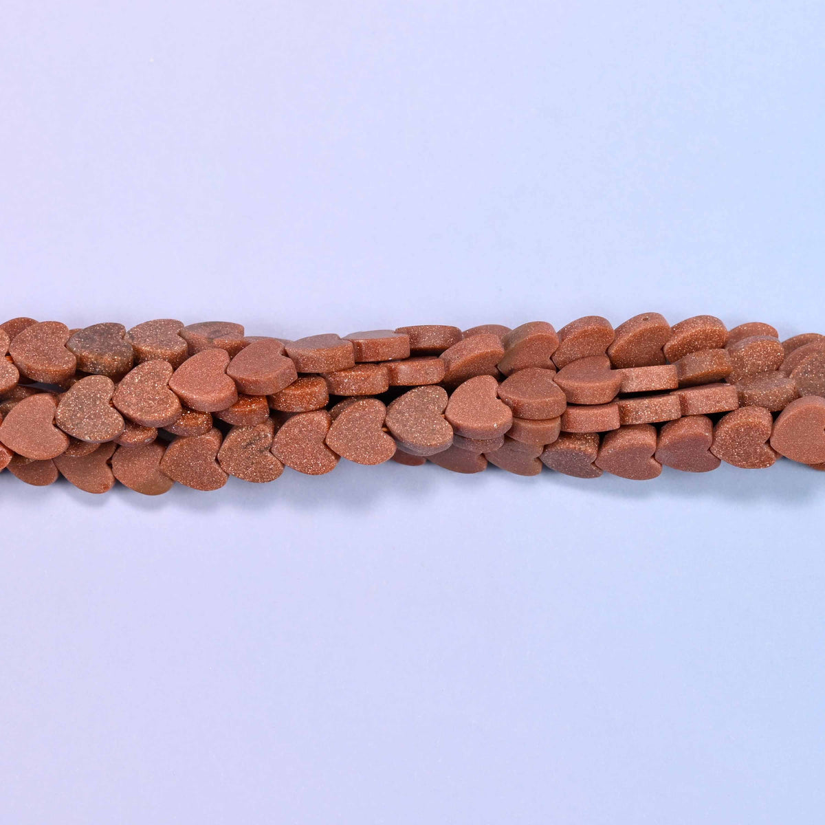 Gold sandstone (man-made glass) matte flat heart beads in warm terracotta-brown with softened copper glitter for a subtle shimmer.