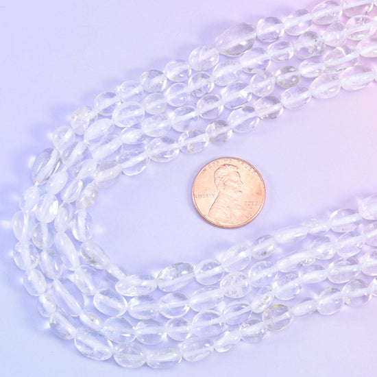 Nugget strands looped beside a US penny for a clear sense of the bead size
