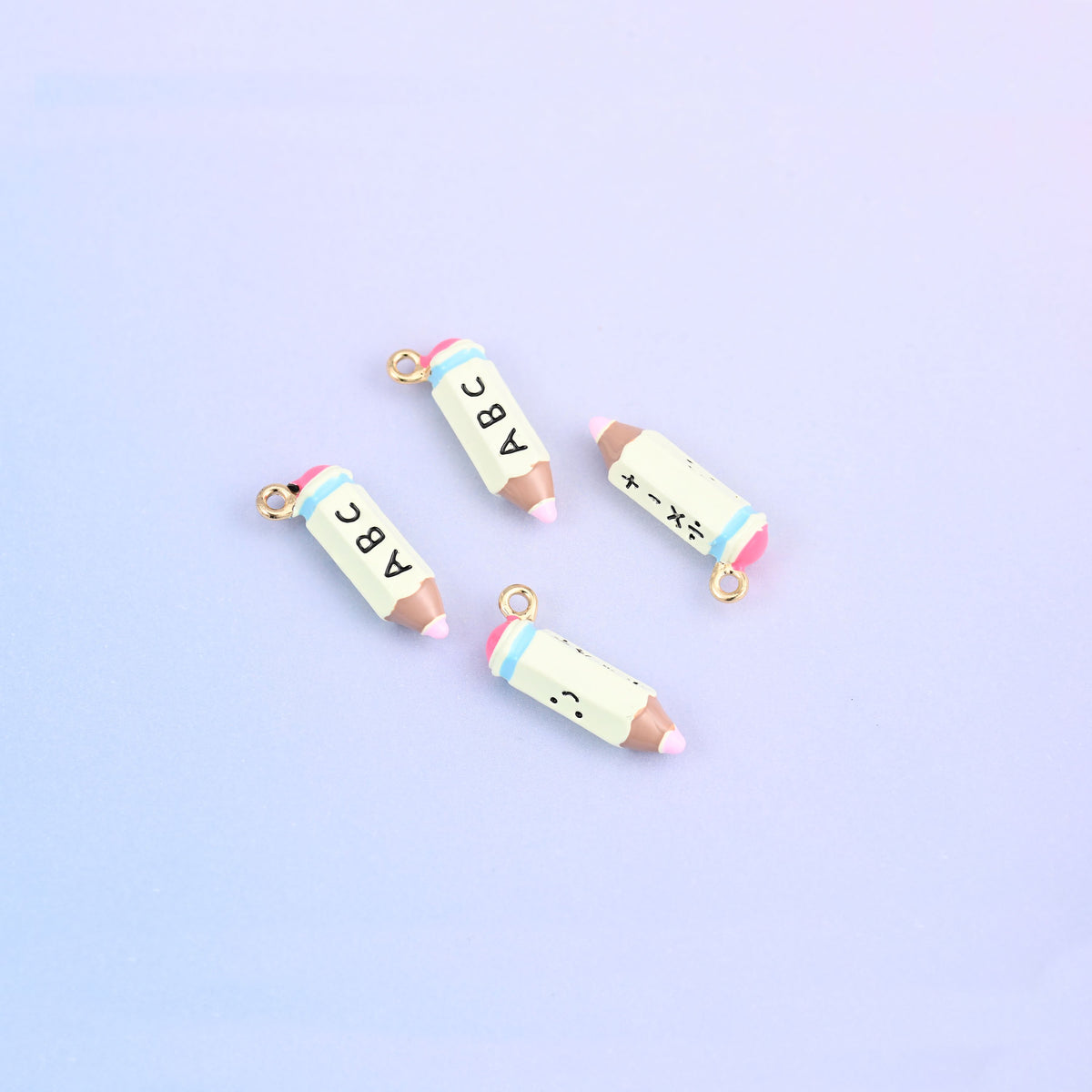 Four light green pencil charms with light blue bands and brown tips.