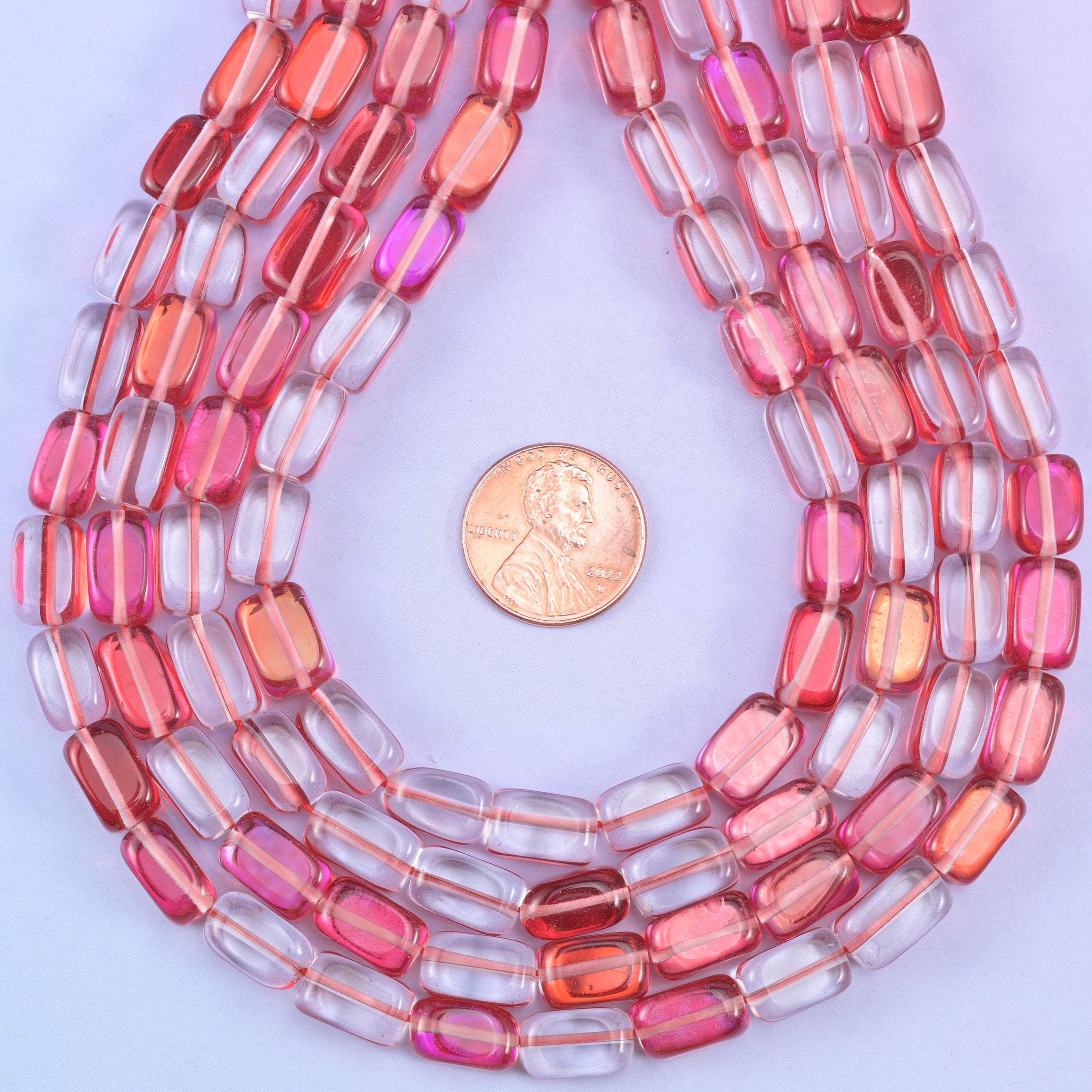 Red Mystic Aura glass beads in a rectangular cut with a glossy transparent finish, featuring a vivid rosy-red shine with a subtle iridescent glow