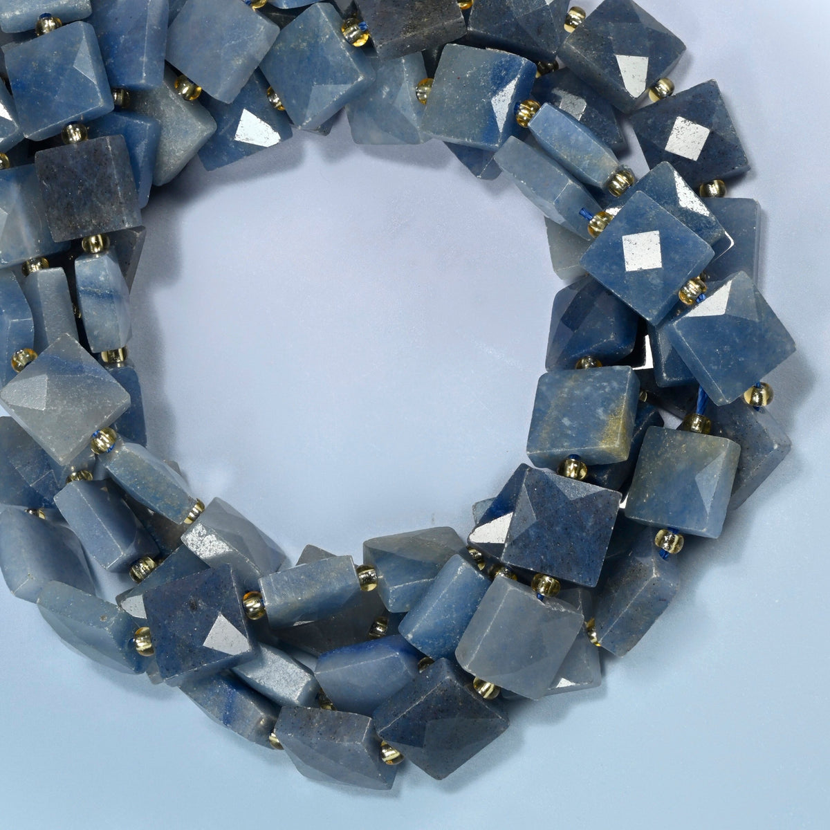 Natural blue aventurine faceted flat square beads coiled into overlapping loops, whole strands of soft denim blue stone