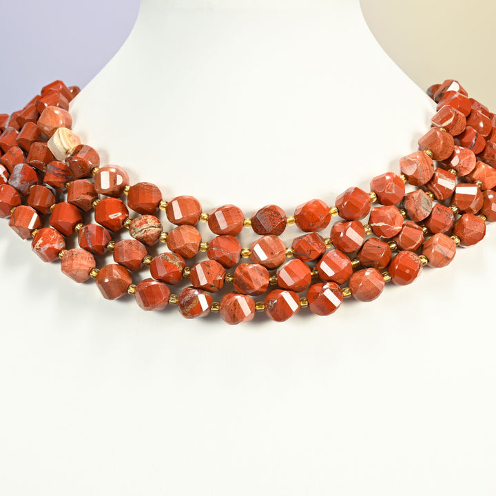 Flower red jasper faceted spiral twist strands arranged as a layered collar on a white display bust, brick red beads across the neck