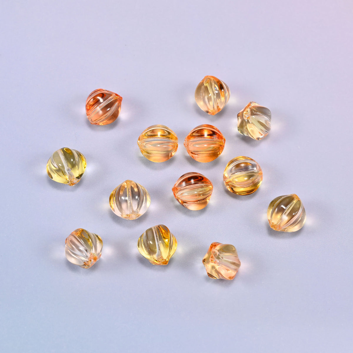 Yellow gold pumpkin glass beads coiled tightly, shown with a US penny in the open center for scale.