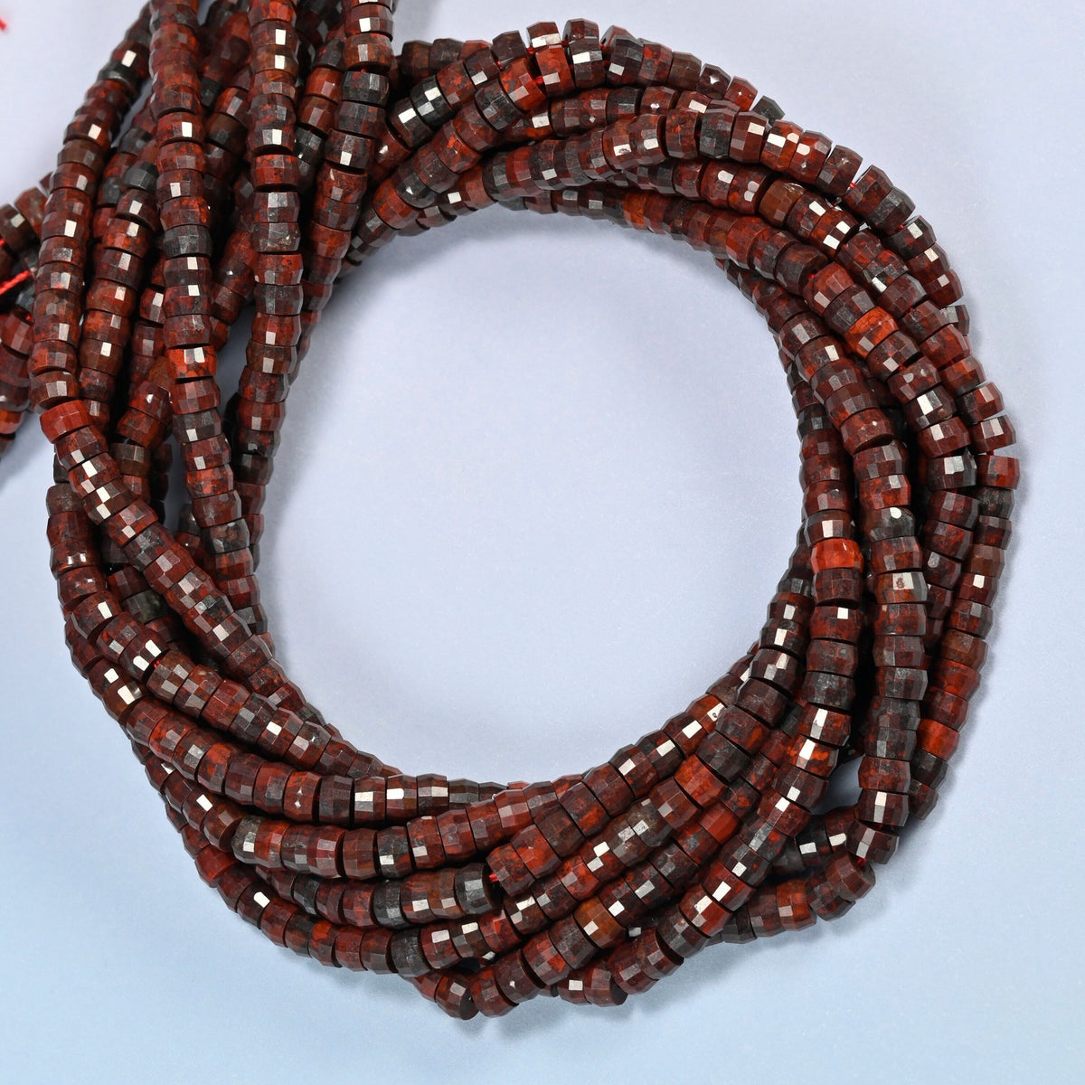 Zhanguo red agate faceted heishi disc beads coiled into overlapping loops, whole strands of deep red-brown stone