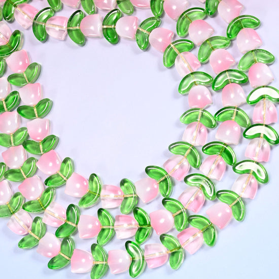 Circular coil of tulip and leaf glass bead strands on a lavender background with a penny in the center for size comparison.