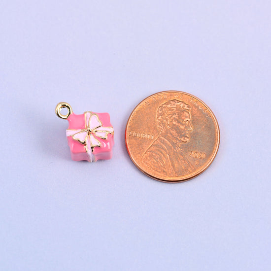 Pink gift box charm shown at actual size, a cube of roughly 9.5mm.
