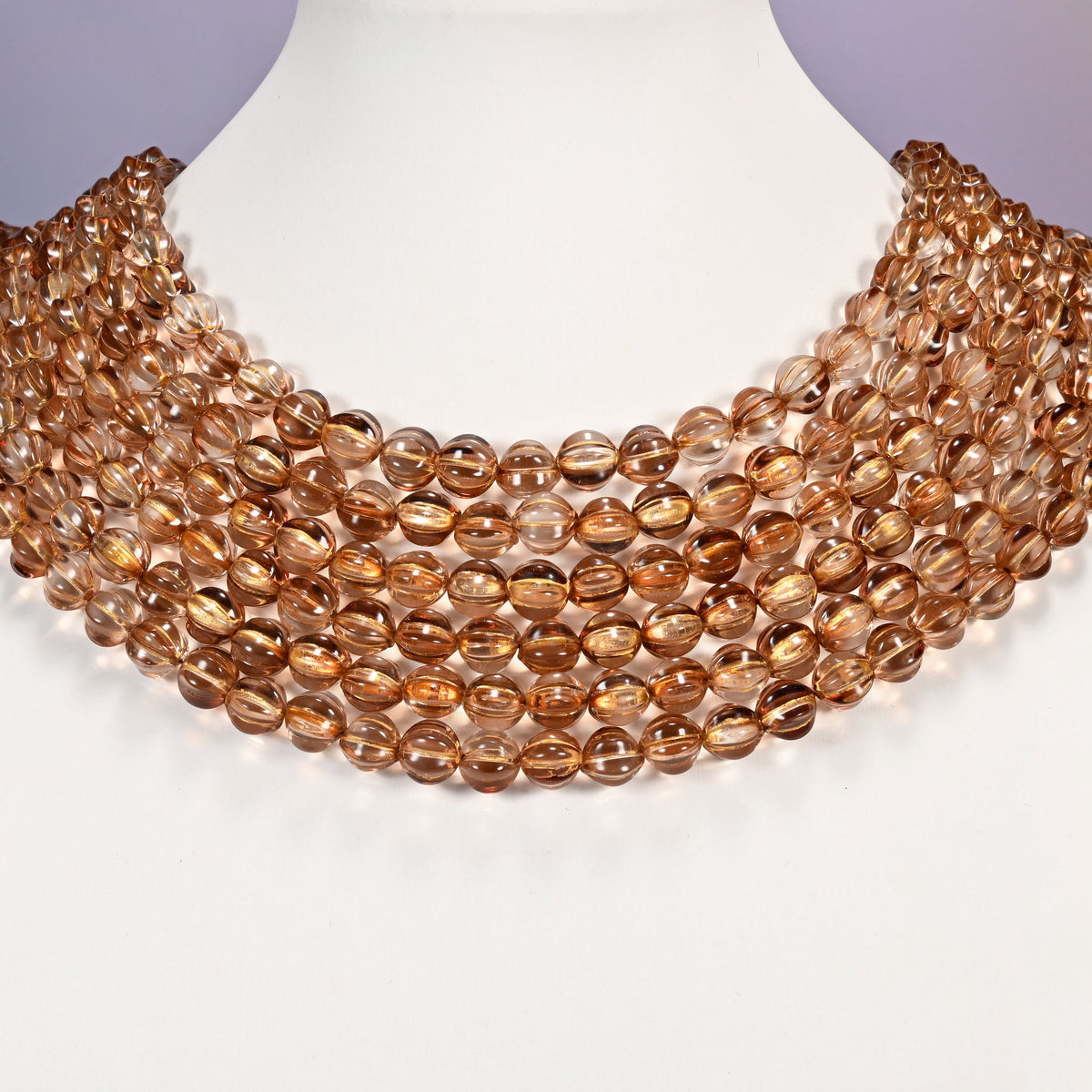 Mystic Aura Brown pumpkin glass beads shown as layered strands on a white neck display form.