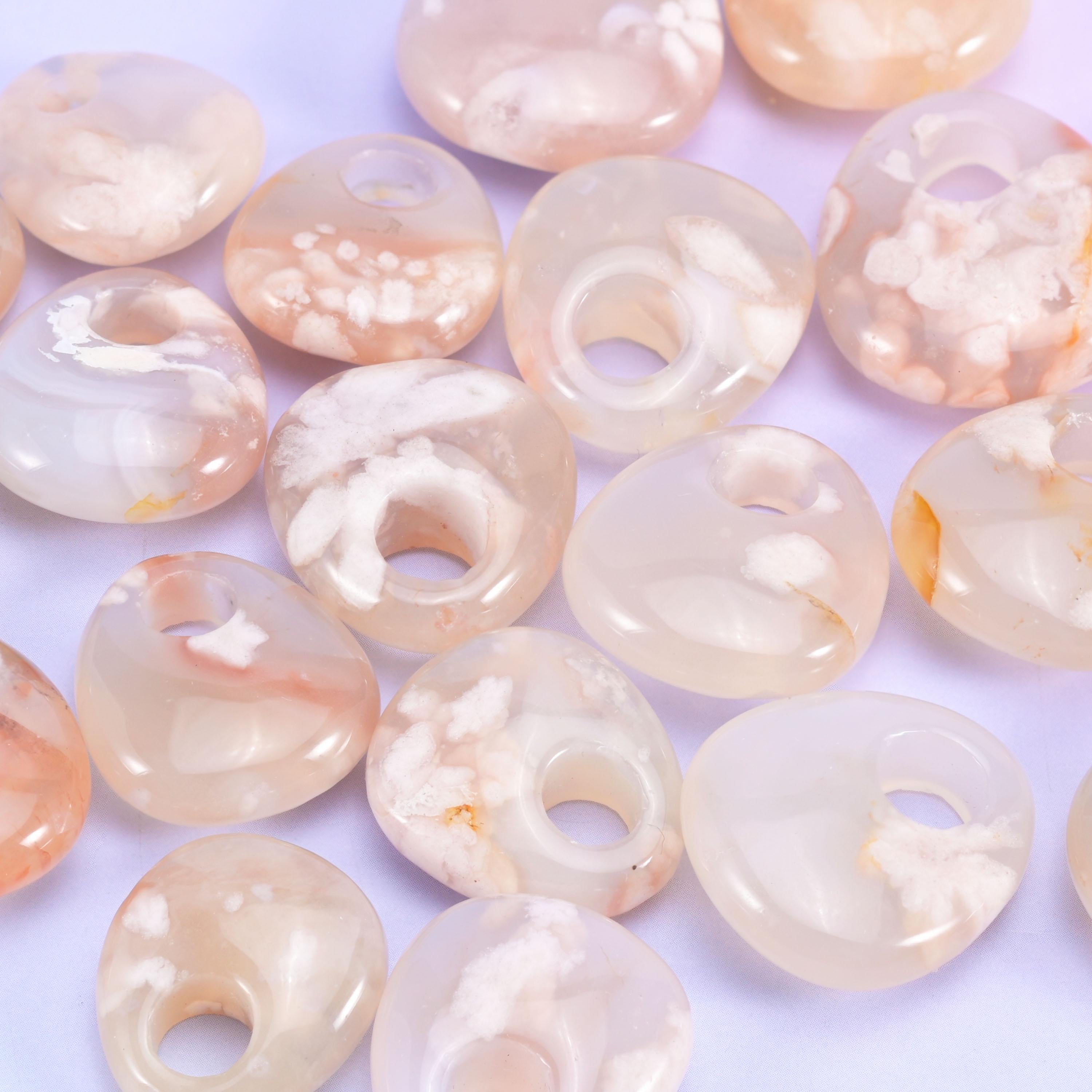 Pale cream and blush agate discs, polished until softly translucent at the rim, scattered with white plume clusters