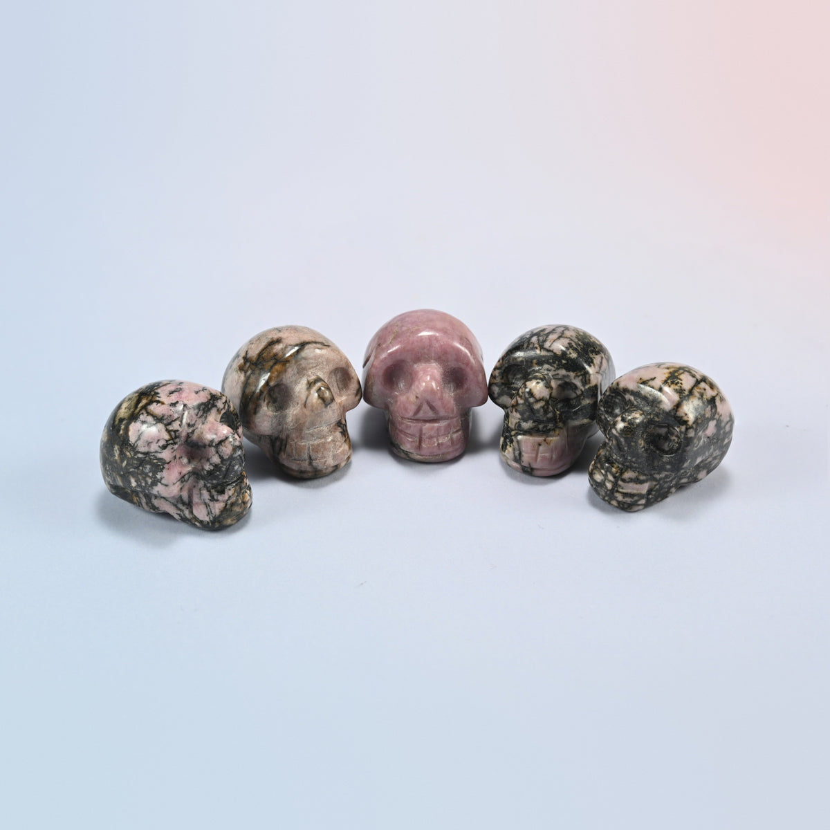 1 inch skull crystal carving in rhodonite, pink natural stone with black veining