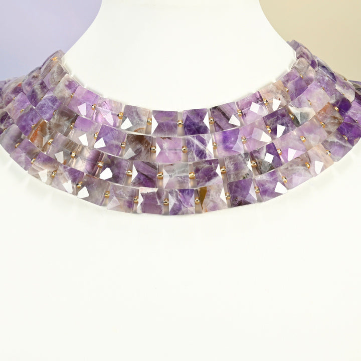 Natural amethyst faceted flat square strands arranged as a layered collar on a white display bust, purple beads across the neck