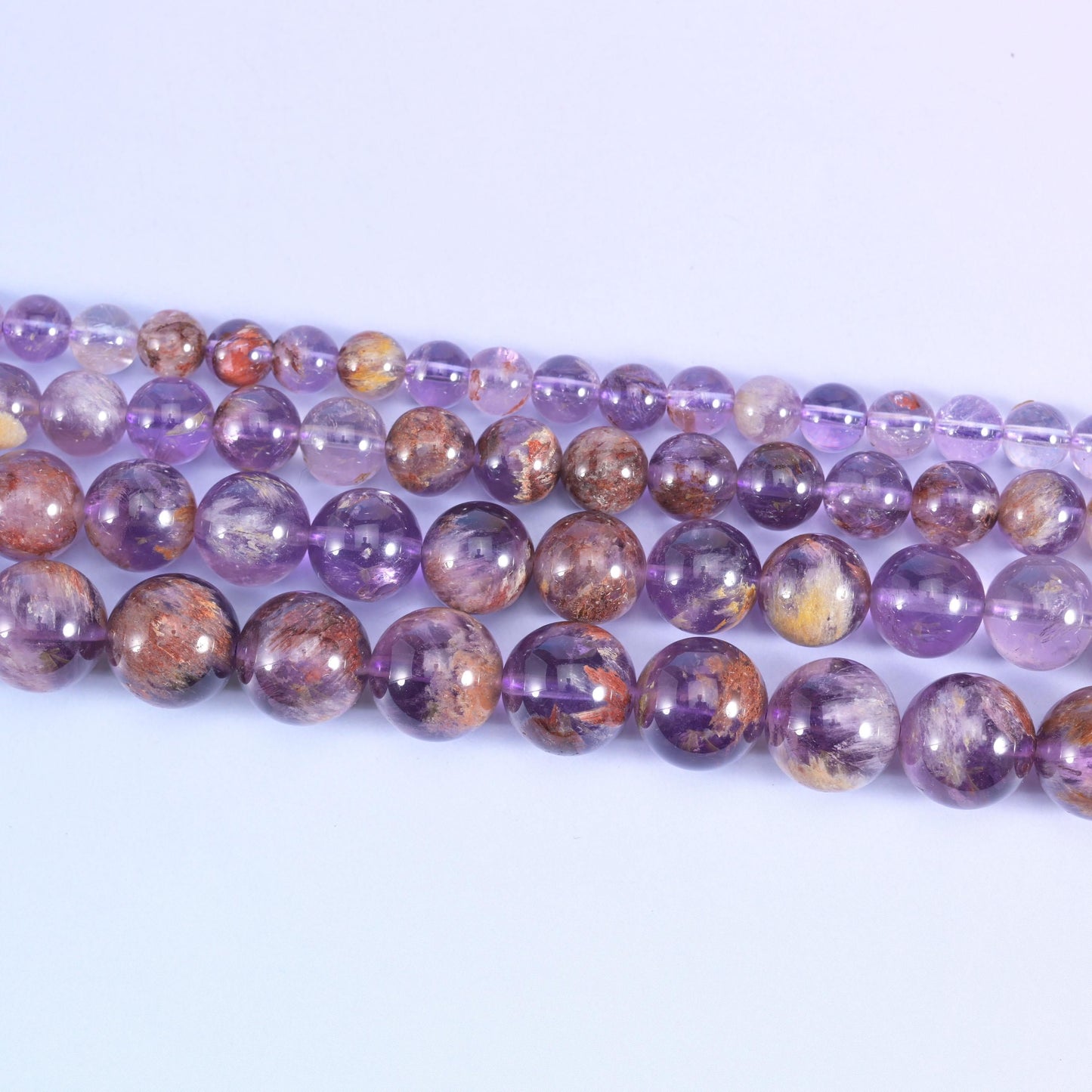 Super 7 purple phantom round beads in translucent lilac to grape