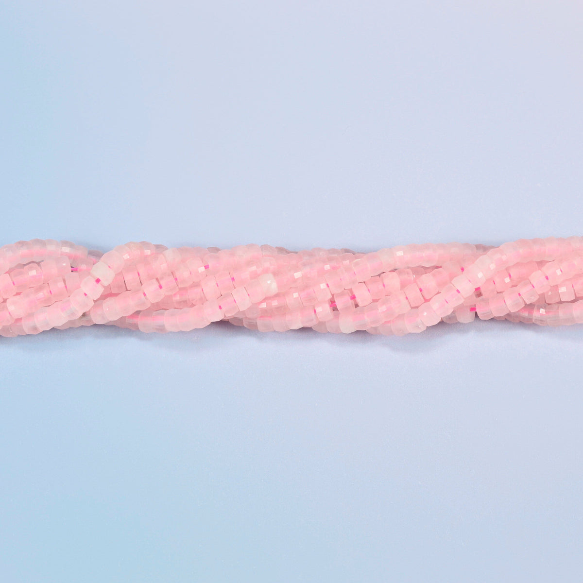 Strands of rose quartz faceted heishi disc beads twisted together in a horizontal row
