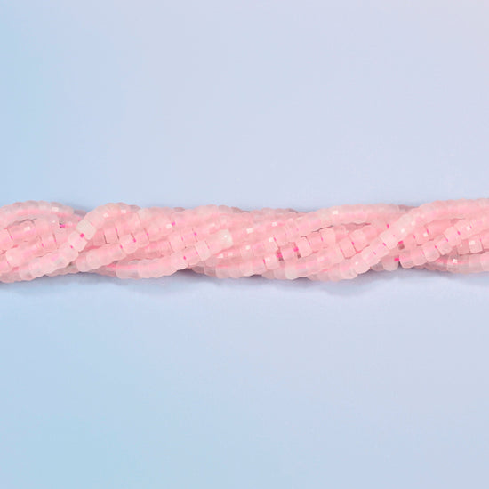 Strands of rose quartz faceted heishi disc beads twisted together in a horizontal row