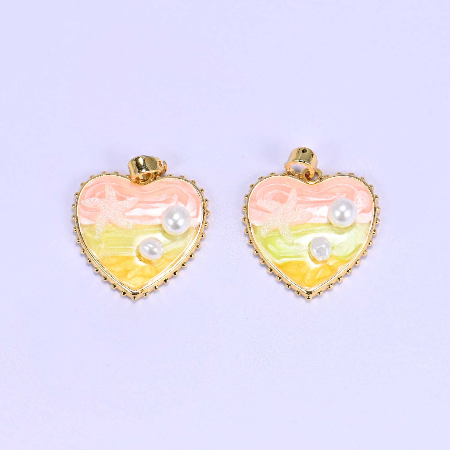 Enamel Heart Pendants in pink, a close pair with the starfish motif and faux pearls set into the swirled pink and yellow enamel.
