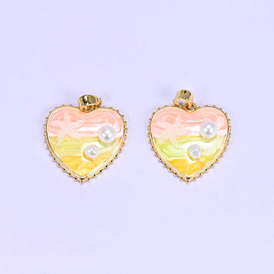 Enamel Heart Pendants in pink, a close pair with the starfish motif and faux pearls set into the swirled pink and yellow enamel.