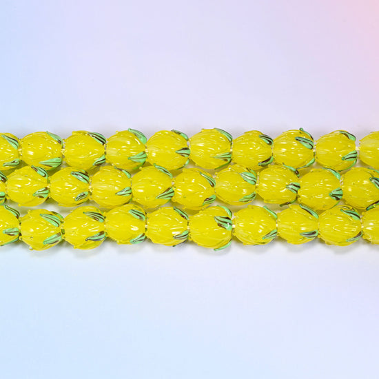 Yellow tulip bud glass beads in translucent yellow with a green leaf detail at the base
